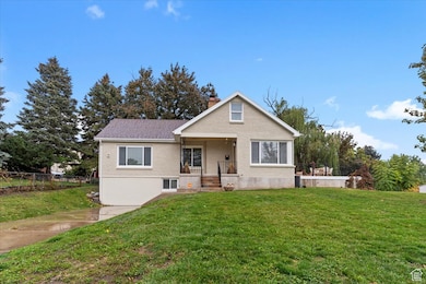 Bungalow-style house with a front lawn, a chimney, covered porch, and brick siding