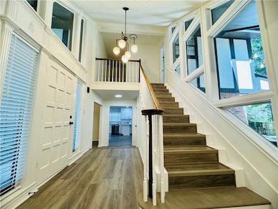 Foyer entrance with a notable chandelier, a toweri