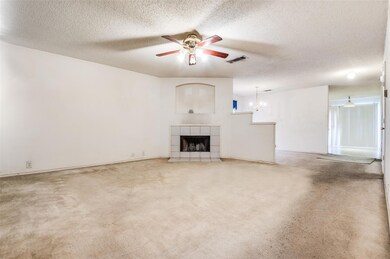 Unfurnished living room featuring ceiling fan, a t