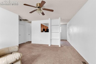 Unfurnished living room with light carpet, ceiling fan, and a textured ceiling