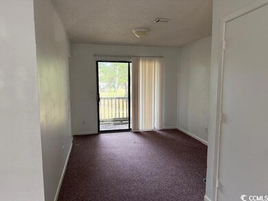 Empty room with carpet flooring, visible vents, ba