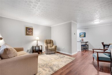Living area featuring ornamental molding, baseboar