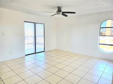 Living room featuring a ceiling fan, a healthy amount of sunlight, and light tile patterned floors