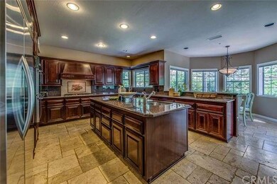 The spacious kitchen boasts Travertine floors, gra