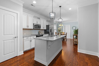 The kitchen features a custom-built island with soft-close drawers, decorative woodwork, and a granite countertop.