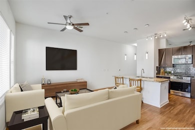 Living area featuring visible vents, ceiling fan,