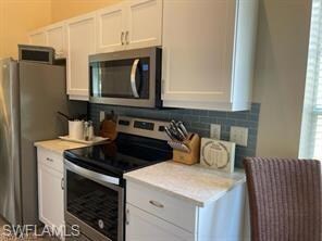 Kitchen with stainless steel appliances, white cab