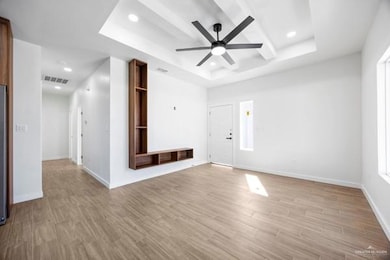 Entrance foyer with a tray ceiling, light wood finished floors, ceiling fan, and recessed lighting
