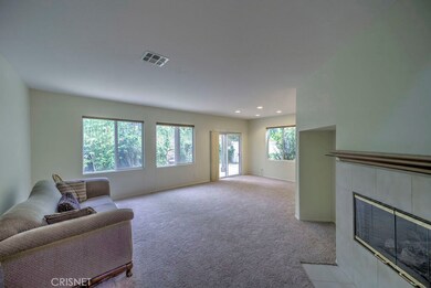 Large living room with fireplace.  Has location for large screen TV.   Fantastic natural light from all of the windows looking out to rose bushes, lemon trees and fig trees.
