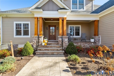 Doorway to property with a porch, roof with shingles, and board and batten siding