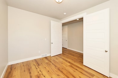 Unfurnished bedroom featuring baseboards and light wood-style flooring