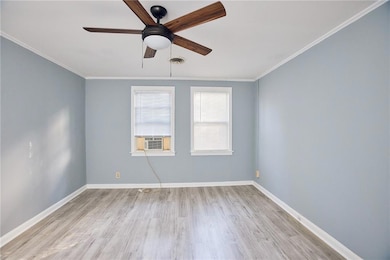 Unfurnished room with a ceiling fan, cooling unit, wood finished floors, and crown molding