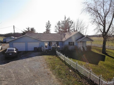 Ranch-style home featuring driveway, a shingled roof, and an attached garage