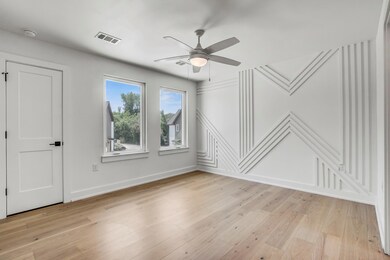 Empty room featuring ceiling fan, a decorative wa