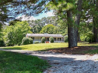 Single story home featuring a front yard, a chimney, and driveway