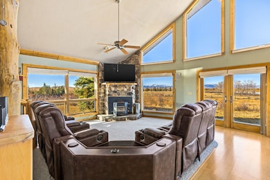 Living room with high vaulted ceiling, plenty of natural light, a ceiling fan, and wood finished floors