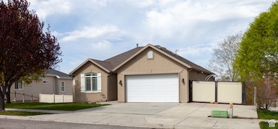 Ranch-style home with concrete driveway, fence, RV access and a garage.