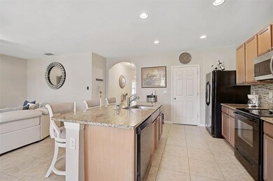 The granite island offers ample space for meal prep, dining, and entertaining, serving as the stunning centerpiece of the kitchen.