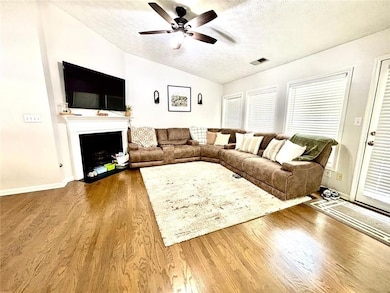 Living room with lofted ceiling, a ceiling fan, a 