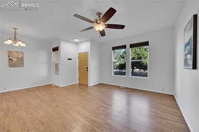 Empty room featuring light wood-type flooring, a chandelier, and a ceiling fan