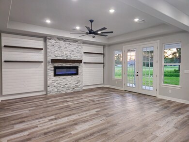 Living room with a stone fireplace, built-in float