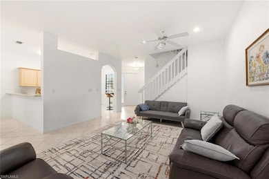 Living area featuring stairway, arched walkways, light tile patterned floors, a ceiling fan, and recessed lighting