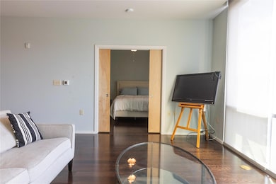 Bedroom with dark wood-style flooring and baseboa
