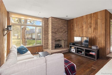 Living area featuring plenty of natural light, wood walls, a fireplace, and dark wood-style floors