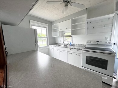 Kitchen featuring sink, white appliances, ceiling fan, and white cabinetry