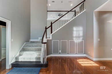 Stairs with wood finished floors, ceiling fan, baseboards, a towering ceiling, and recessed lighting