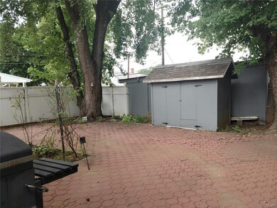 The yard is paved with garden areas
