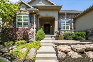View of exterior entry with stone siding and stucco siding