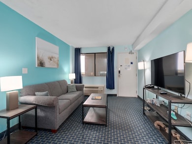 Living area featuring carpet flooring, baseboards,