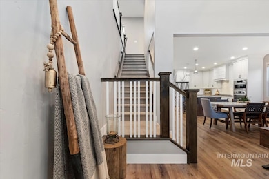 Staircase with wood finished floors and recessed lighting