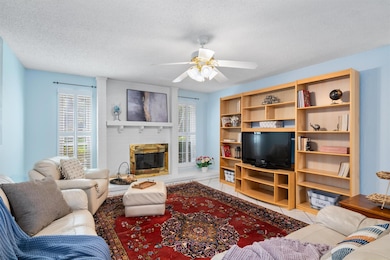 Tiled living room with ceiling fan, a textured ce