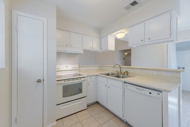 Kitchen with white appliances, a sink, under cabi