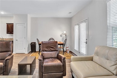 Living room with light wood-style flooring and baseboards
