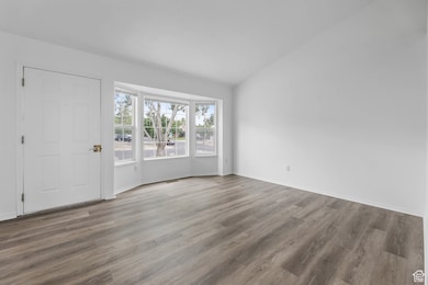 Entryway featuring wood finished floors and vaulted ceiling