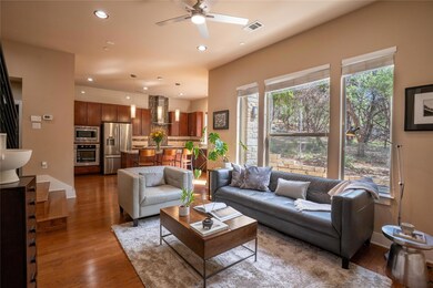 Living area featuring a ceiling fan, wood finishe