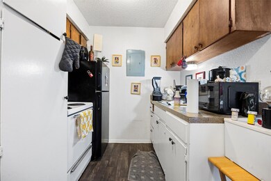 Kitchen featuring a textured ceiling, dark wood-t