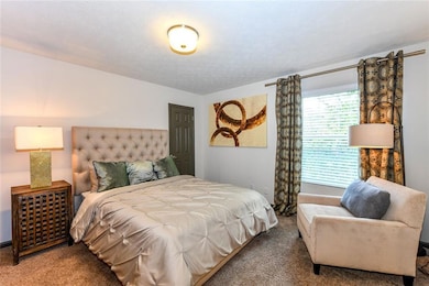 Bedroom with carpet floors and a textured ceiling