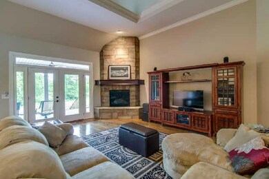 Open Living Room to Kitchen with Fireplace And Door To Covered Porch