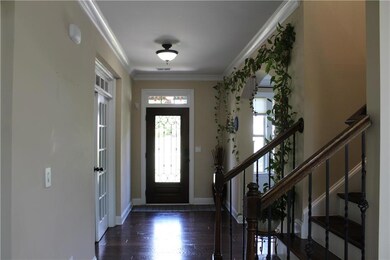 Foyer entrance with wood finished floors, stairs, and crown molding