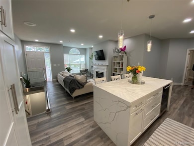 Kitchen with white cabinetry, pendant lighting, recessed lighting, a fireplace, and light stone countertops