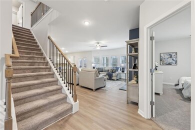 Stairs with ceiling fan, baseboards, wood finished