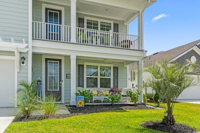 View of front of home featuring covered porch, a balcony, a garage, and a front lawn