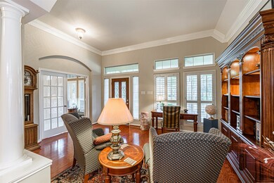 The formal living room features crown molding, wood floors, plantation shutters and plenty of natural light.