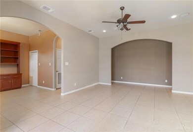 Tiled spare room featuring ceiling fan and built in shelves