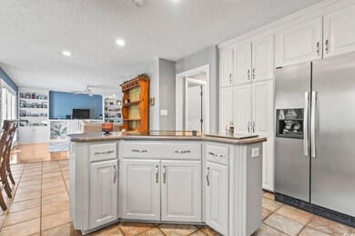 Kitchen with a ceiling fan, a kitchen island, stai