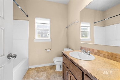 Bathroom featuring vanity, washtub / shower combination, and stone finish floors